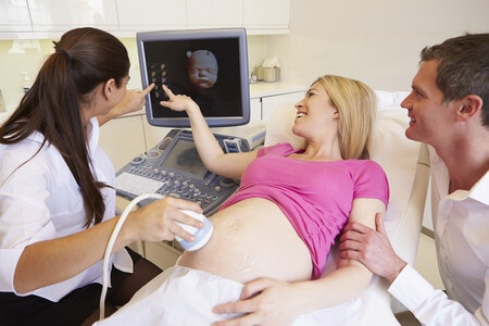 תמונה של זוג הורים במהלך בדיקת אולטרסאונד להריון - TLV MEDICAL CENTER