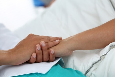 רופאה ומטופלת מחזיקות ידיים - הפסקת הריון